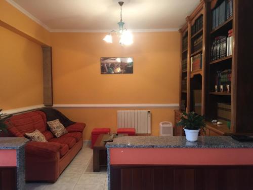 sala de estar con sofá y sofá rojo en Pisos Turísticos Muxía- Teresa Barros -bajo-, en Muxía