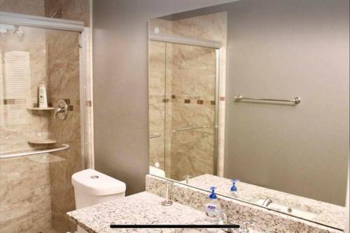 a bathroom with a shower and a toilet and a sink at CYC Lounge with Guest House in San Antonio