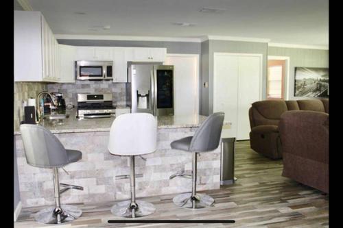 a living room with two chairs and a kitchen at CYC Lounge with Guest House in San Antonio