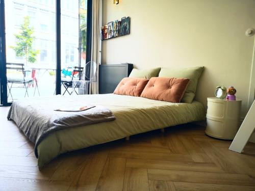 a large bed in a room with a wooden floor at Luxurious Central Studio in Monumental Warehouse in Rotterdam