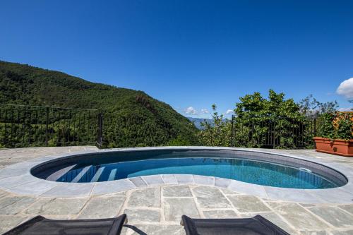 a swimming pool with two chairs and a mountain at Antichi Sentieri in Serravalle