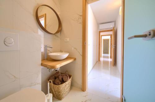Un baño con lavabo, inodoro y espejo. en Villa Rossa, en Županje
