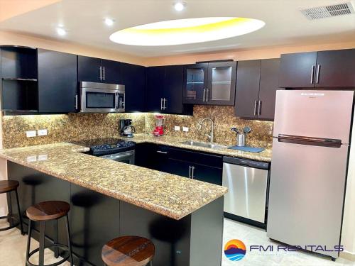a kitchen with black cabinets and a white refrigerator at Linda Vista 513 in Puerto Peñasco