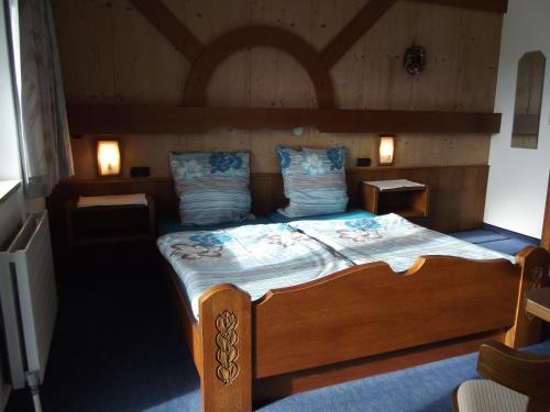 a bedroom with a large wooden bed with two lamps at Haus Margit in Kössen