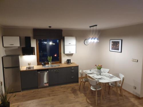 Apartamenty i Domki Mierzeja في شتوتوفو: مطبخ وغرفة طعام مع طاولة وكراسي