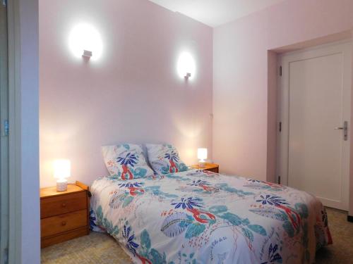 a bedroom with a bed and two lights on the wall at Du coq à l'âme in Naves