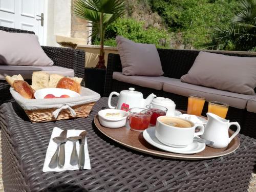 a table with a breakfast of coffee and toast at Les Gîtes du Moulin d Olt in La Canourgue