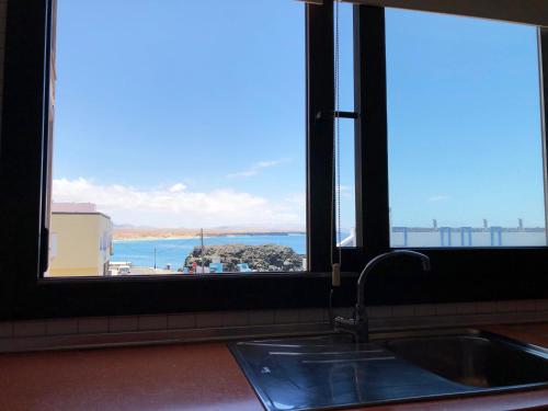 a kitchen with a sink and a view of the ocean at Cotillo Ocean View in Cotillo