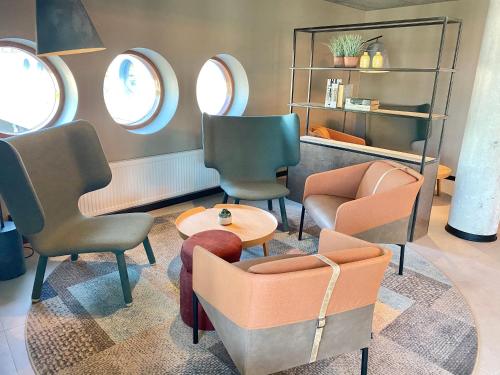 a waiting room with chairs and a table at Pilot Airport Hotel in Vantaa