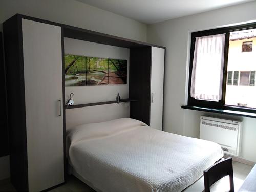 a bedroom with a white bed and a window at B&B L'Acero in Casto