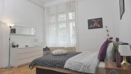 a white bedroom with a bed and a window at River Center Apartment in Budapest