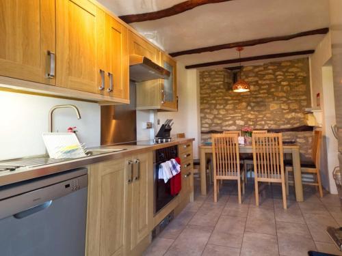 Kirkdale Cottage في هلمسلي: مطبخ مع حوض وطاولة وكراسي