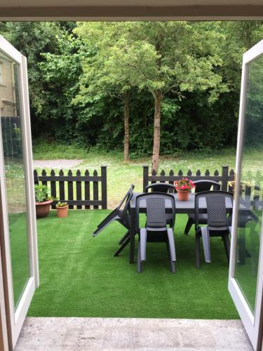 a patio with a table and chairs on the grass at No.14 in Bunratty