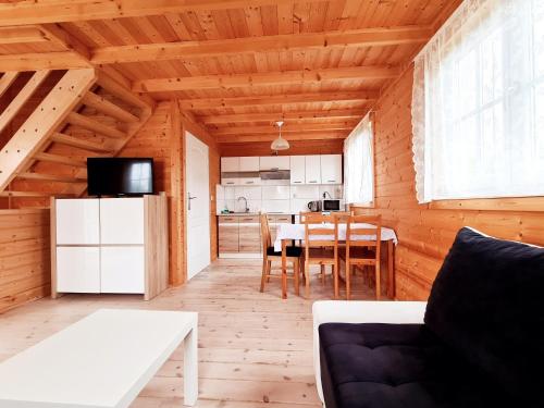 a living room with a table and a kitchen at Domki Gościniak in Rewal