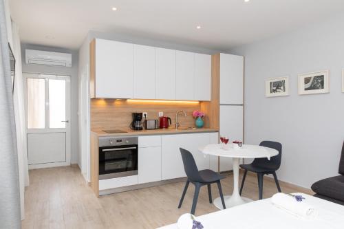 a small kitchen with a table and chairs in a room at Apartman Ružica in Pučišća