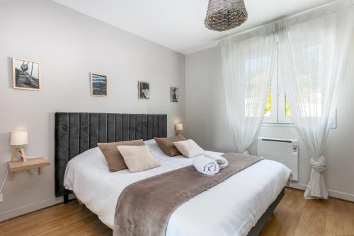 a bedroom with a large bed with a large window at L' Évéa Garden in Le Relecq-Kerhuon