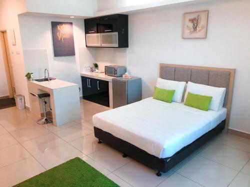 a small bedroom with a bed and a kitchen at Agrima Studio Apartment in Kota Bharu