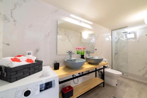 a bathroom with two sinks and a toilet and a mirror at Elounda Buena Vista Apartment in Elounda