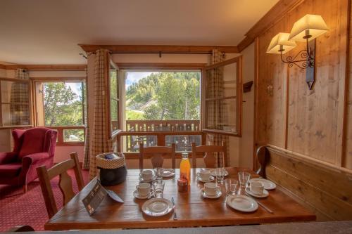 une salle à manger avec une table et une fenêtre dans l'établissement L'Ekrin des Arcs - Arc 1950 Le Village - Duplex 6-8 pers, à Arc 1950