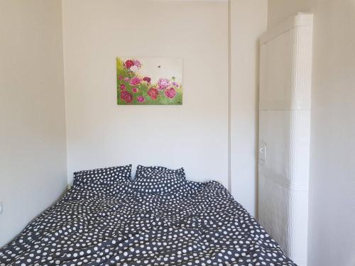 een bed in een slaapkamer met een foto aan de muur bij Aia Apartment in Haapsalu