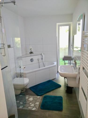 a bathroom with a tub and a toilet and a sink at Apartments Alice & Julia in Baden-Baden