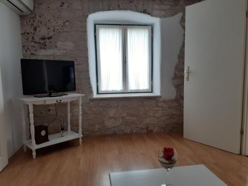 a living room with a television and a window at Apartma Fiorina in Sečovlje