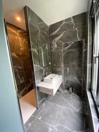 a bathroom with a sink and a shower at LA VILLA AUBIN belle demeure avec vue sur Paris in Montmorency