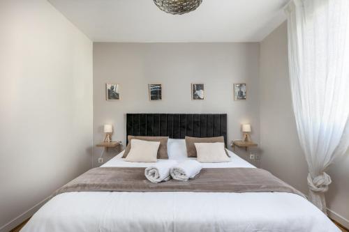 a bedroom with a large bed with two towels on it at L' Évéa Garden in Le Relecq-Kerhuon