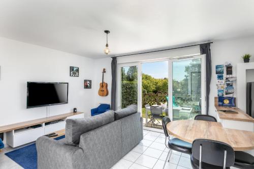 a living room with a couch and a table at L' Évéa Garden in Le Relecq-Kerhuon
