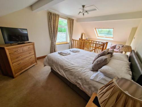 a bedroom with a bed with a television and a dresser at The Haven in Keswick