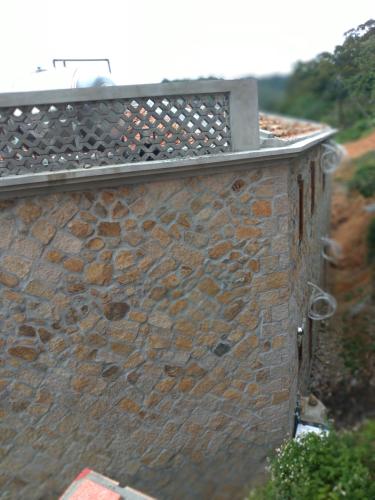 a brick wall with a fence on top of it at mei hao min su in Nangan