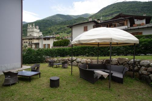 a table and chairs under an umbrella in the grass at Locanda al Crap in Tresivio