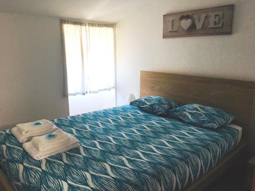 a bedroom with a bed with two towels on it at SwordFish Holiday Home in Peniche