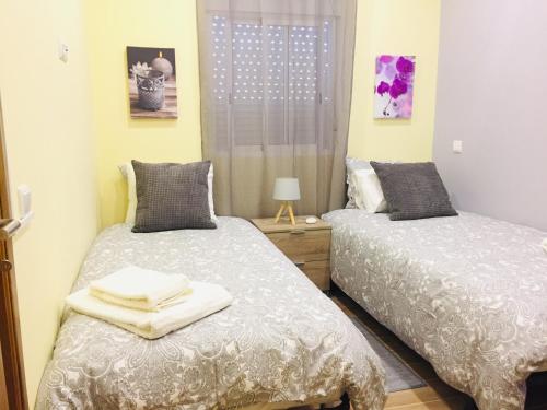ein Schlafzimmer mit zwei Betten und einem Fenster in der Unterkunft Quinta dos Netos in Tavira