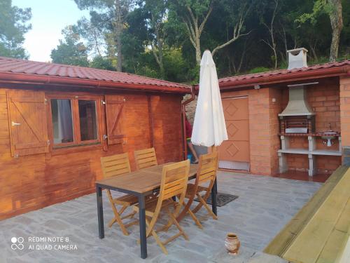 a table and chairs and an umbrella on a patio at Casa das Vinhas Velhas by Casa do Poço in Peso da Régua
