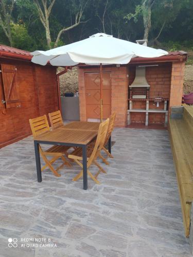 a table and chairs with an umbrella on a patio at Casa das Vinhas Velhas by Casa do Poço in Peso da Régua