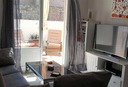 a living room with a couch and a flat screen tv at Bonito Ático en el centro de la ciudad in Sanlúcar de Barrameda