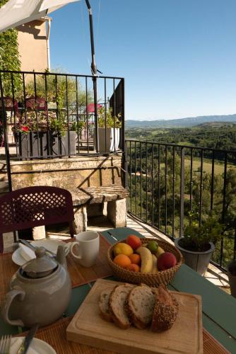 - une table avec un bol de fruits et une corbeille de pain dans l'établissement Les Maisons Mado, à Venasque