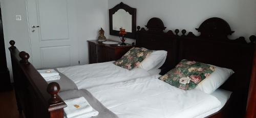 a bedroom with a bed with white sheets and flowers at Dworek pod świerkami in Jelenia Góra