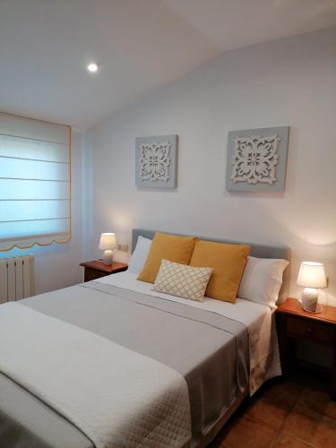 a bedroom with a large bed with two lamps at Apartamentos Marsó in Poio