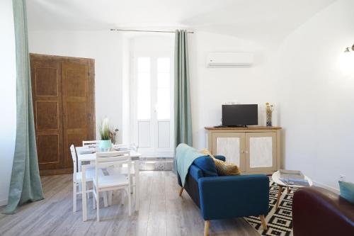 a living room with a blue couch and a table at Appartement Gaudin in Bastia