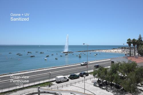 a highway next to a beach with boats in the water at Ocean View Penthouse in Paço de Arcos