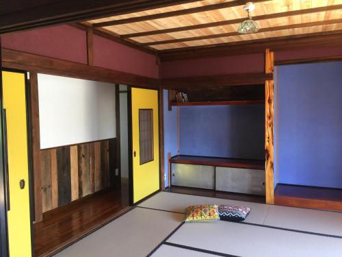 an empty room with a bed in the middle at 一棟貸し宿bochi-bochi in Komagane