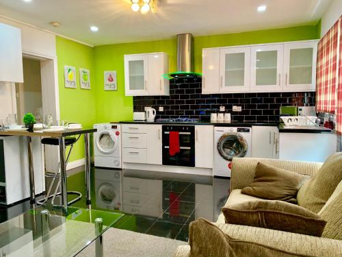 uma cozinha com electrodomésticos brancos e paredes verdes em London Luxury 2Bedrooms, Reception, Garden, Apartment em Ilford