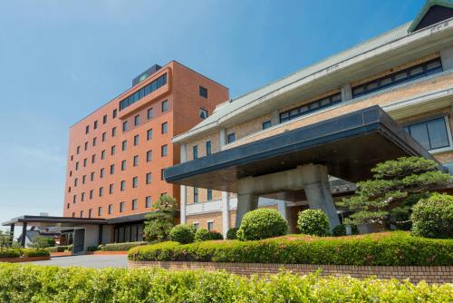 a building with a sculpture in front of it at Izumo Royal Hotel in Izumo