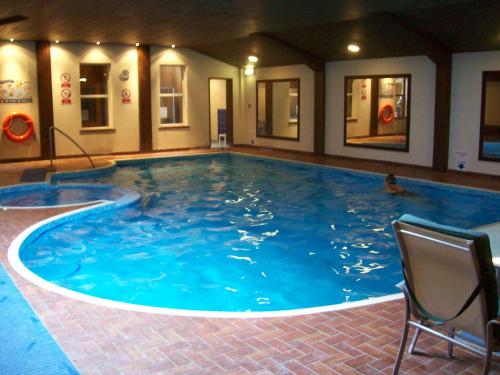a large swimming pool in a hotel with two people in it at Elstead Hotel in Bournemouth