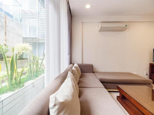 a living room with a couch and a large window at Glenwood Residences in Ho Chi Minh City