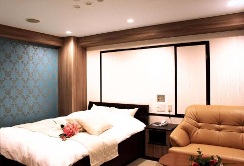 una camera con letto e sedia di Pal Annex Oita (Love Hotel) a Oita