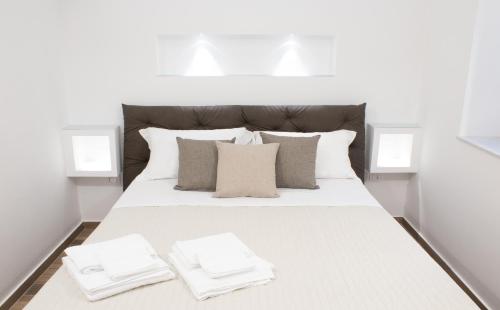 a large white bed with two white towels on it at Cortile Osterio XIV in Cefalù