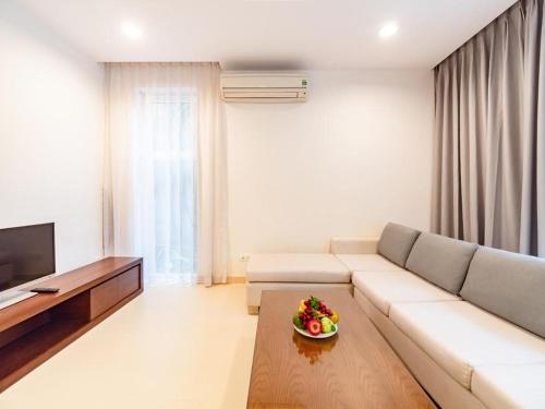 a living room with a couch and a bowl of fruit on a table at Glenwood Residences in Ho Chi Minh City